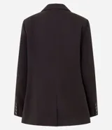 Blazer de sastrería en color negro, de corte alargado y estructura recta. Presenta solapas clásicas, cierre frontal con dos botones, hombros estructurados y mangas largas con detalle de botones en los puños. Incluye bolsillos decorativos y forro interno.