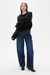 Sweater de tejido de punto color negro, con cuello redondo a la base, mangas largas y diseño holgado.