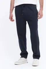 Pantalón de jogging con corte recto y ajuste relajado, confeccionado en tejido de algodón y poliéster. Cuenta con cintura elástica con cordón de ajuste y bolsillos laterales funcionales.