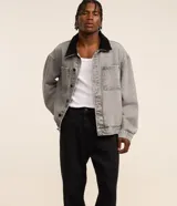 Pantalon de jean gris con lavado deslavado, de corte baggy y silueta holgada. Cuenta con bolsillos al frente y atras, y cierre de boton y cremallera.