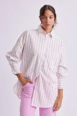Camisa oversize blanca con rayas verticales rosas, de manga larga con puños abotonados, cuello clásico y bolsillo de parche en el pecho.