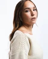 Sweater color crema de lana merino con cuello bote y mangas largas.