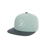 Gorra tipo trucker con visera plana, cuerpo en color verde menta y visera en tono gris oscuro melange. Presenta el logotipo bordado de la marca en el panel frontal dentro de un círculo blanco.
