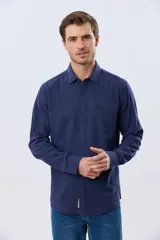 Camisa de lino de manga larga en color beige, con cuello camisero, cierre frontal de botones y un bolsillo ojal en el pecho.