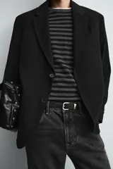 Blazer de corte relajado confeccionada en tejido fluido con mezcla de viscosa. Presenta cuello con solapas de muesca, manga larga con puños abotonados, bolsillos de solapa en la cadera y cierre frontal con botones.