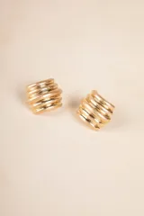 Par de aros dorados con forma cuadrada y diseño con relieve de líneas horizontales.