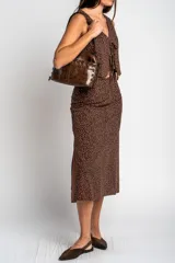 Falda midi de corte recto, color marrón con estampado de lunares pequeños en tono claro. Presenta un diseño de tiro alto y largo hasta la pantorrilla.