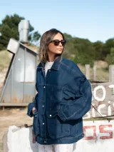 Campera de jean azul con cuello clásico, cierre frontal con botones, mangas largas y bolsillos con solapa en el pecho.