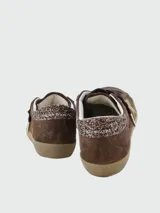 Zapatillas Golden Goose modelo Super Star, confeccionadas en gamuza color marrón con estrella lateral en gamuza dorada y detalle de glitter en el talón. Presentan cordones oscuros y suela de goma con efecto desgastado.