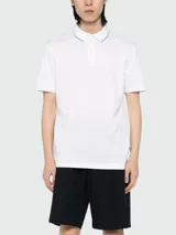 Polo de pique BOSS de color blanco, de manga corta, con cuello y puños acanalados que presentan detalles en contraste. Cuenta con cierre frontal de botones.