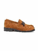 Mocasines de gamuza color marrón, con suela plana y detalle de cadena eslabonada negra en el empeine.