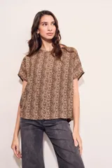 Blusa color beige con estampado animal print en marrón, de corte holgado y mangas cortas.