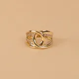 Anillo de oro 10k con diseño de nudo central y bandas laterales decoradas con pequeñas circonias engastadas.