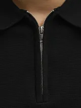 Polo de punto estructurado color negro, con cuello polo, cierre frontal parcial con cremallera y mangas cortas.