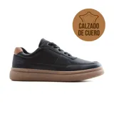 Zapatilla casual Hi-Tec modelo Otto, confeccionada en cuero negro con suela de goma color caramelo y detalle en el talón en tono marrón claro.