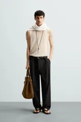 Camiseta tipo tank (sin mangas) de punto, color beige claro, con cuello redondo amplio y corte relajado.