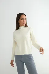 Polera negra de tejido de punto acanalado, con cuello alto y mangas largas.