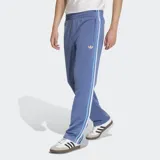 Pantalón de jogging azul con cintura elástica ajustable con cordón, bolsillos laterales con cierre y logo Adidas bordado en dorado. Presenta las tres tiras clásicas de Adidas en blanco y celeste a lo largo de la pierna.