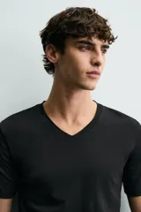Camiseta blanca de algodón con elasticidad, corte slim fit, cuello en V y mangas cortas.
