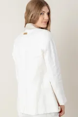 Blazer azul de lino con corte entallado, cuello y solapas combinadas en color gris, cierre con botón de nácar, bolsillos laterales y tajo en la espalda.