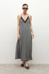 Vestido midi de tirantes finos con estampado de cuadros vichy en blanco y negro, escote en V y detalle de encaje en el dobladillo.