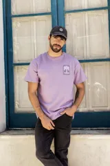 Gorro con visera de algodón color gris oscuro, con ligero lavado y estampa bordada de un logo con un planeta.