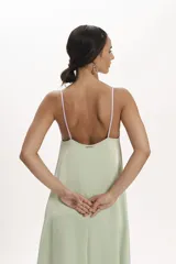 Vestido midi de satén con diseño bicolor en tonos verde agua y lila. Presenta un corte holgado, escote en V con tirantes finos y una franja central vertical en color lila que contrasta con el cuerpo del vestido.