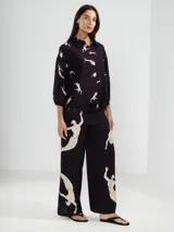 Camisa de manga larga color rosa con rayas verticales rojas y estampado de flores rojas. Con cuello camisero, puños elastizados y lazos regulables en los costados del ruedo.