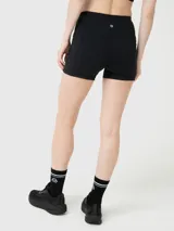 Conjunto deportivo compuesto por un top de escote redondo y espalda deportiva, y un short de tiro alto ajustado. Ambas piezas son de color negro y diseño liso.