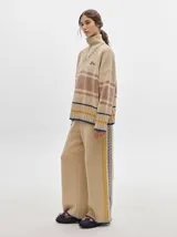 Pantalón de punto con textura tipo terciopelo, de corte ancho y holgado. Presenta cintura elástica con cordón de ajuste y detalle de pespuntes decorativos en los laterales.