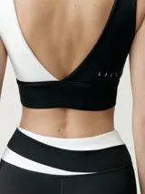 Calza deportiva color negro con detalle de banda blanca en la cintura y elástico cruzado, corte ajustado.