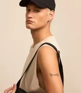 Musculosa básica para hombre de corte recto y cuello redondo, confeccionada en tejido de algodón. Presenta un diseño liso con un pequeño tag decorativo en el bajo.