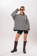 Buzo tejido de algodón con rayas verticales blancas y negras, de corte oversize.