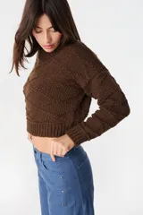 Sweater crop de tejido de punto color chocolate, con cuello redondo y diseño de rombos en relieve. Presenta puños y ruedo acanalados.