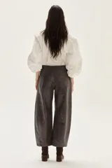 Pantalón de efecto cuero (PU) color gris oscuro/marrón, de tiro medio y calce barrel (pierna ancha y redondeada).