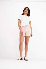 Short de denim bicolore estilo patchwork, con una pierna en tono rosado y la otra en beige.