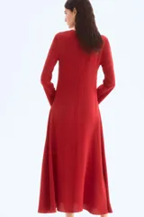 Vestido midi rojo de manga larga, con escote redondo y corte evasé con nesgas laterales para dar volumen.