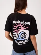 Remera negra de ajuste holgado con gran estampado en la espalda que incluye un sol, una ola, símbolos y las inscripciones "made of sun" y "ocean calm".