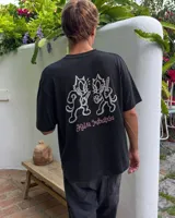 Remera de manga corta negra con diseño gráfico en la espalda que muestra dos gatos animados con cuchillos y el texto 'Kaboa Industries'.