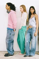 Jeans de denim celeste lavado, corte boyfriend ancho, tiro medio, con roturas y apliques/bordados en forma de corazón en diferentes partes de las piernas.