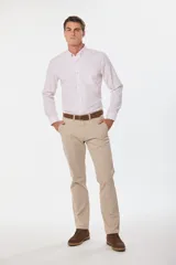Pantalón de gabardina color marrón claro, corte slim fit, con bolsillos laterales y traseros. Se ajusta a la cintura con cinturón de cuero marrón.