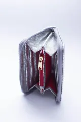 Billetera marrón tipo sobre con cierre de cremallera, confeccionada en cuero con textura tipo cocodrilo y forro textil rojo. Cuenta con múltiples ranuras para tarjetas, documentos y billetes.