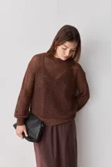 Sweater de punto calado color marrón, con cuello redondo y mangas largas de diseño liviano y translúcido.