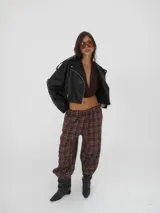 Pantalón de corte ancho con cintura elástica y bolsillos laterales, estampado a cuadros en tonos marrones.