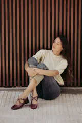 Sweater de punto color tostado con hilos metalizados, de corte recto, escote redondo y mangas cortas con puño ajustado.