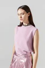 Top tejido de punto color rosa con lúrex, sin mangas y cuello a la base.