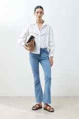 Camisa blanca de manga larga con detalles de encaje en el frente y las mangas.