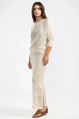 Falda midi color crema, tejida a crochet con aberturas en la parte inferior.