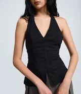 Blusa frente única de Blue Steel, confeccionada en bengalina color negro. Presenta un escote profundo en V, corte ajustado en la parte superior con ruedo levemente ampliado y bolsillos laterales decorativos.