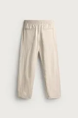 Pantalón de corte relajado confeccionado en una mezcla de algodón y lino. Presenta cintura elástica con cordón ajustable, bolsillos laterales y bolsillos traseros de vivo.